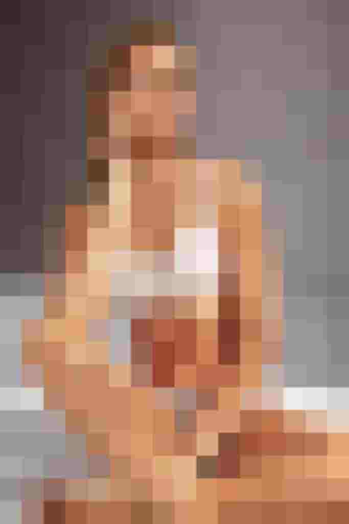 Frau in weißer Spitzenunterwäsche sitzt auf dem Boden