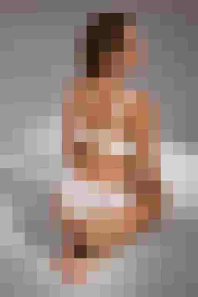 Frau in weißem Spitzen-BH und Slip kniet auf dem Boden